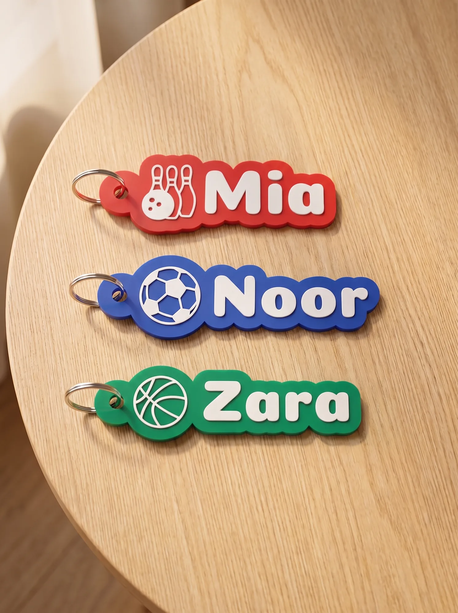 Name keychains for Mia, Noor and Zara with sports icons
