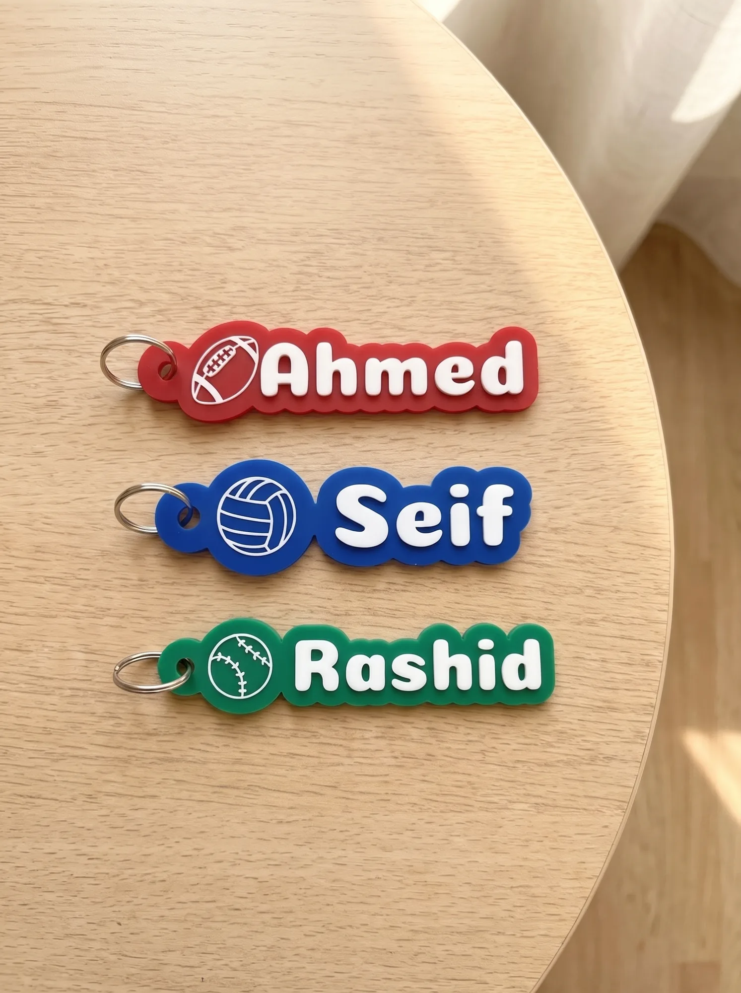 Name keychains with American football, volleyball and baseball icons